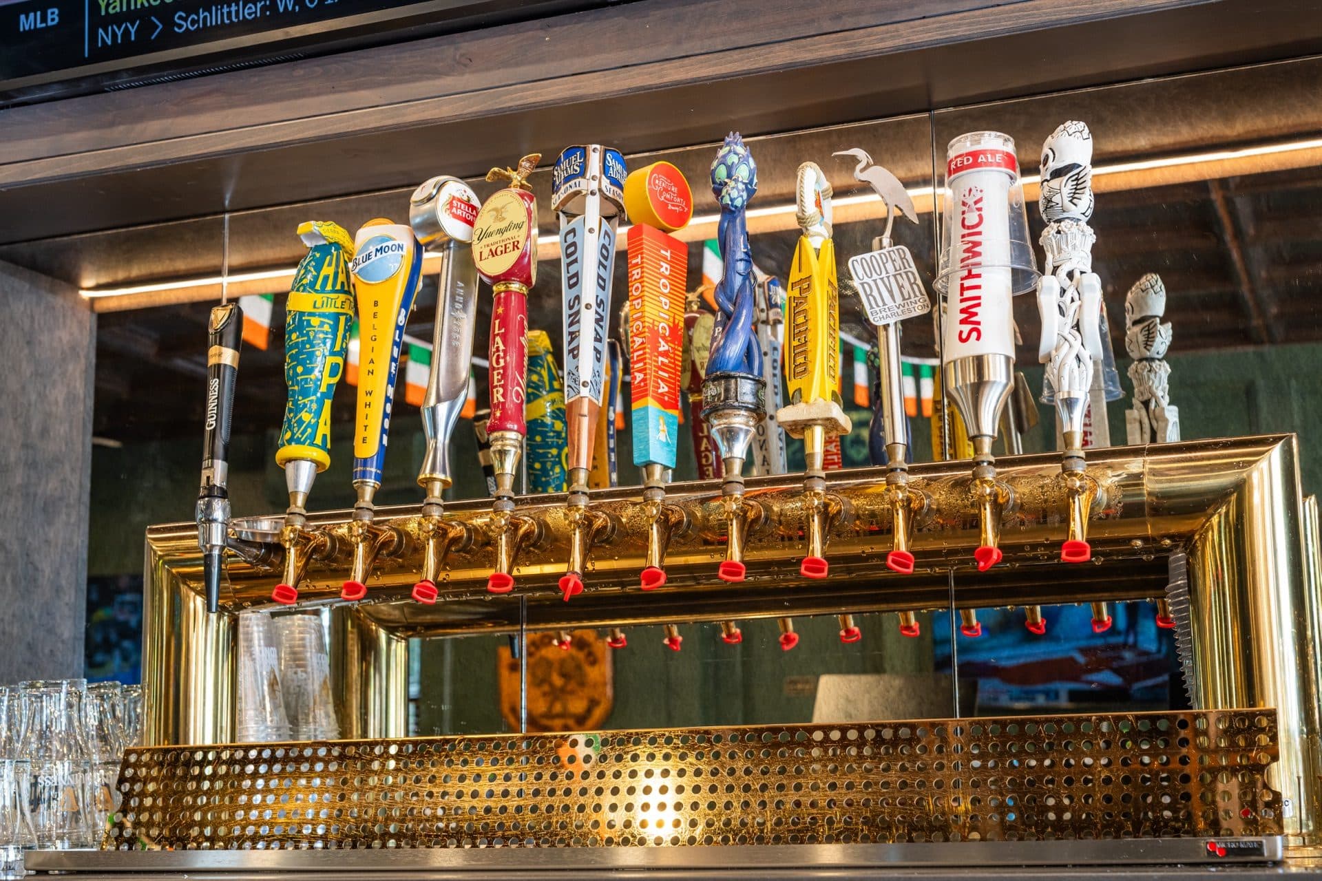 Draft Beer on Tap at O'Brion's Pub & Grille — Craft, Import & Domestic, Mount Pleasant SC Brass draft beer tap handles at O'Brion's Pub & Grille bar in Mount Pleasant SC showing a wide selection of craft and domestic beers on tap