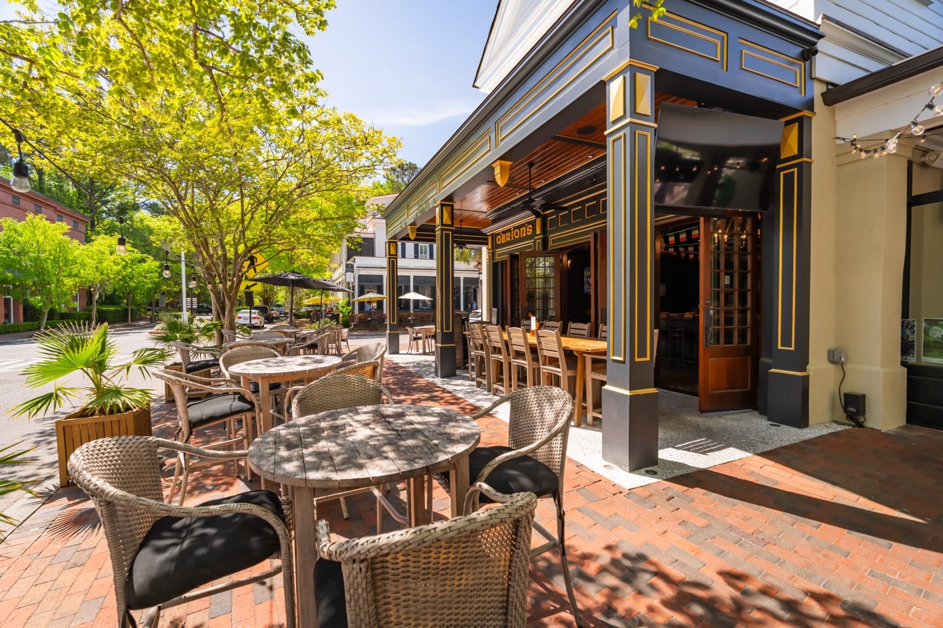 Open-Air Patio at O'Brion's Pub & Grille — Neighborhood Irish Pub in I'On Village Street-level view of O'Brion's Pub & Grille patio and exterior facade in I'On Village Mount Pleasant SC with brick walkway and open-air seating