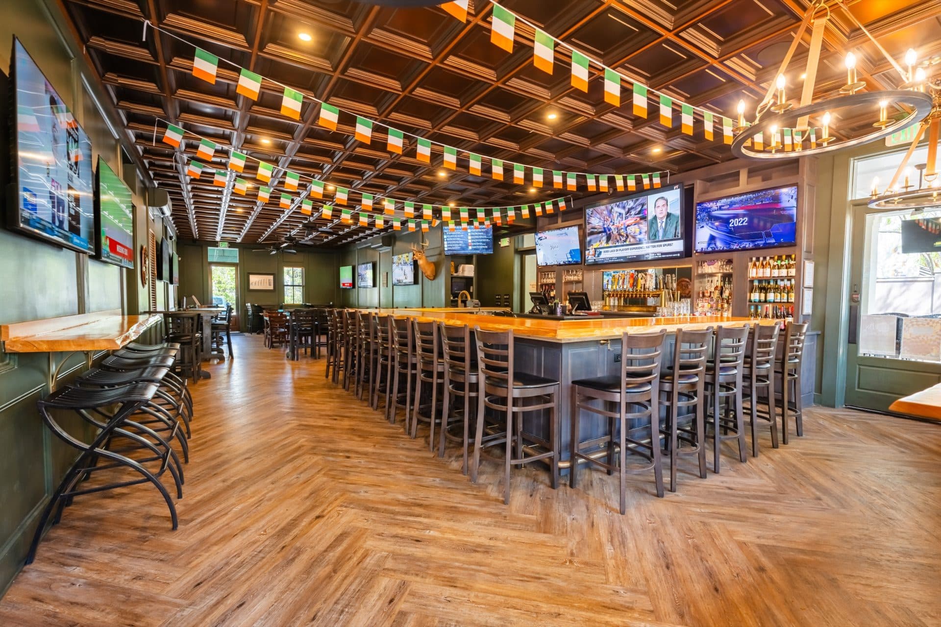 Renovated Irish Pub Bar at O'Brion's Pub & Grille — Sports Bar in Mount Pleasant SC Panoramic view of the renovated bar interior at O'Brion's Pub & Grille in Mount Pleasant SC with Irish flags, wood bar top, and multiple sports TVs